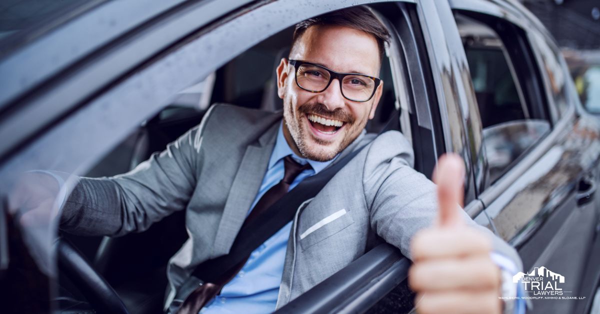 Man in his car giving a thumbs up outside his window.